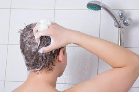 Young man taking a shower Stock Photos