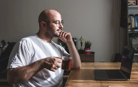 Young man taking a tea break while working at home. Stock Photos