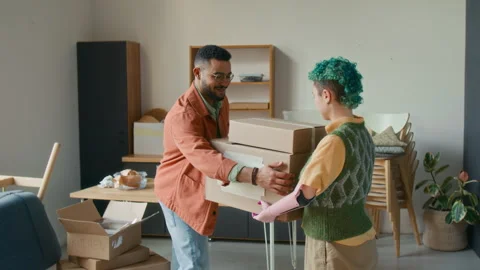 Young Man Taking Two Moving Boxes from Girlfriend while Unpacking Kitchen Items Stock Footage 323301866