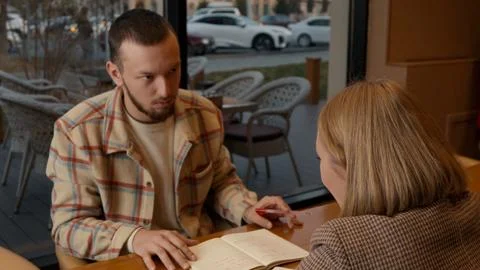 Young man talking and explaining a concept to his partner in a cafe Stock-Fotos