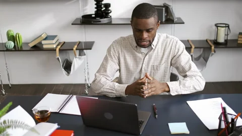Young man is talking and looking at laptop during online meeting at modern Stock Footage 194478640