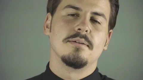 Young man talking to the camera in grey background studio. Stock Footage 76394056