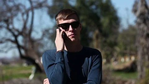 Young man talking on cell phone outdoors Stock Footage 73580313