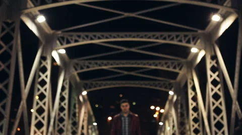 Young man talking on cellphone and walking by the bridge Stockbeeldmateriaal 61097908