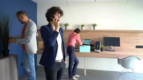 Young man talking on cellphone at modern startup office Stock Footage 104962020
