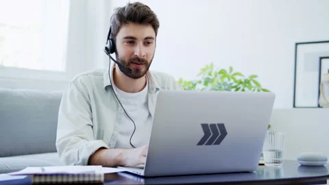 Young man talking during video call while working from home Stock Footage 142534205