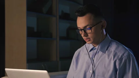 A young man talking on facetime, skype, video chat, dark background Stock Footage 98300108