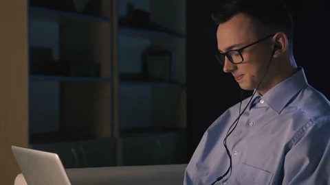 A young man talking on facetime, video chat, dark background Stock Footage 98299744