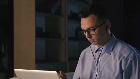A young man talking on facetime, video chat, dark background Stock Footage 98299960