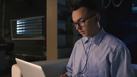 A young man talking on facetime, video chat, dark background Stock Footage 98300505