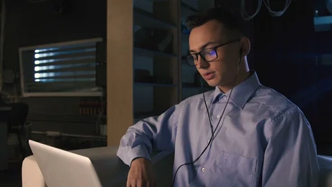 A young man talking on facetime, video chat, dark background Stock Footage 98301006
