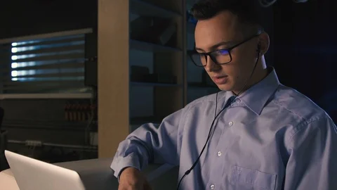A young man talking on facetime, video chat, dark background Stock Footage 98301235