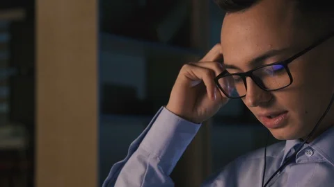 A young man talking on facetime, video chat, dark background, close-up Stock Footage 98301707