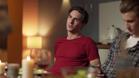 Young man talking to friends at dinner Stock Footage 114815345