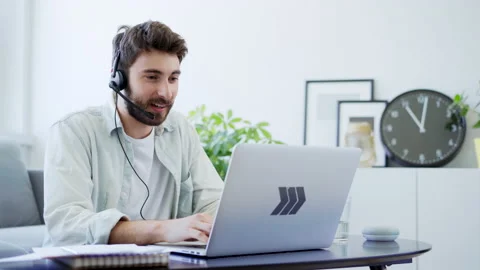 Young man talking with headset while working from home Stock Footage 142535625