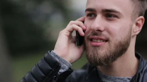Young man talking on his phone outdoors Stock Footage 64032745