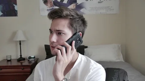 A young man talking on his smartphone 스톡 동영상 75486147