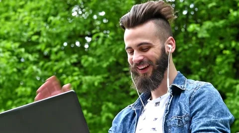 Young man talking online through laptop at the park Stock Footage 62698760