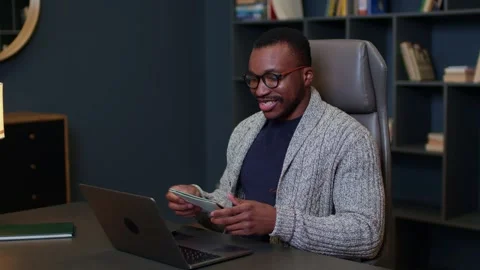 A young man is talking online via video call and jotting down something in Видео 264105989