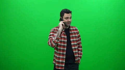 Young Man Talking on the Phone Against a Green Screen Stock Footage 88656642