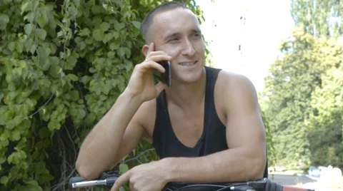 Young man talking on the phone on bicycle Stock Footage 67541019
