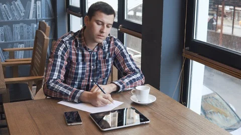 Young man talking on the phone in a cafe Stock Footage 86490491