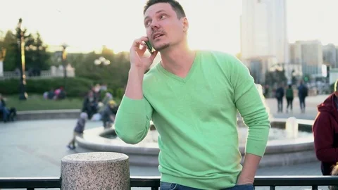Young man talking on the phone in the city at sunset Stock Footage 78480717
