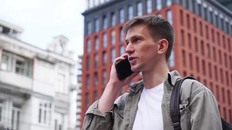 A young man talking on the phone. Close-up. A busy city street Stock Footage 246304595