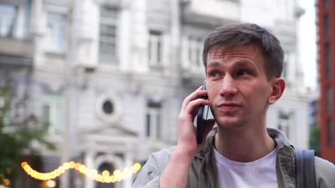 A young man talking on the phone. Close-up. A busy city street Stock Footage 246966500