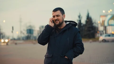Young man is talking on the phone at the evening city street. Stock Footage 84227773