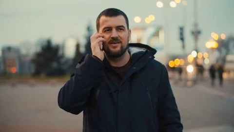 Young man is talking on the phone at the evening city street. Stock Footage 84227799