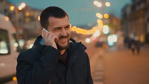Young man is talking on the phone at the evening city street. Stock Footage 84232059