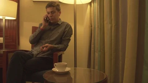 A young man talking on the phone in home interior Stock Footage