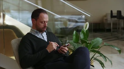 Young man talking on the phone from luxury hotel lobby Vídeos de archivo 70989866