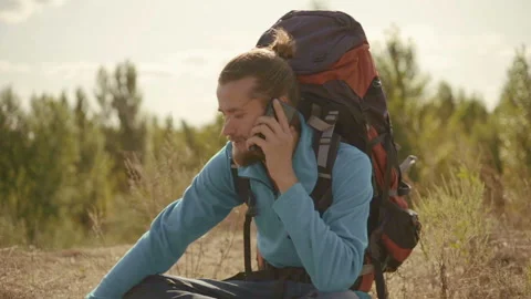 Young man talking on the phone on a mountain hike. Stock-Footage 116505467