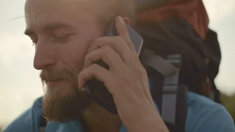 Young man talking on the phone on a mountain hike. Vídeo Stock 116507350