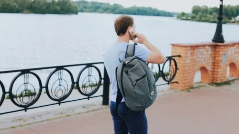 Young man talking on the phone at the waterfront Stock Footage 80493575