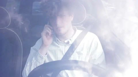 Young man talking on the phone while driving Stock Footage 41571887