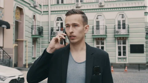 Young man talking on the phone while walking and looking for the right way Stock Footage 134654465