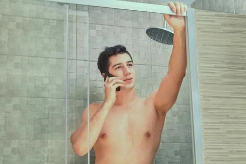 Young man talking on phone while taking a shower. Foto stock