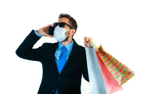 Young man talking on the phone while holding shopping bags Stock Photos
