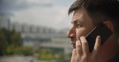 Young man talking on the phone, yard in the background Stock Footage 113284861