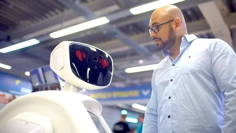 A young man is talking to a robot. Stock Footage 86448232