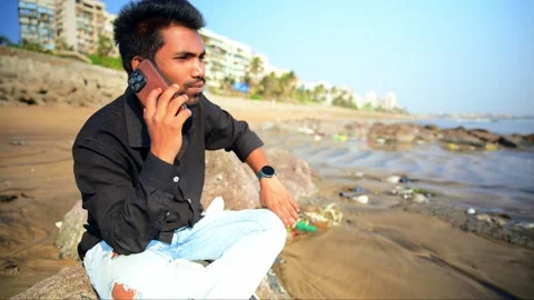 Young Man Talking on Smartphone at the Beach Stock Footage 281318275