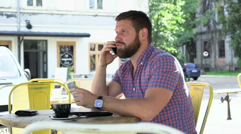 Young man talking by smartphone in cafe 動画素材 67632719