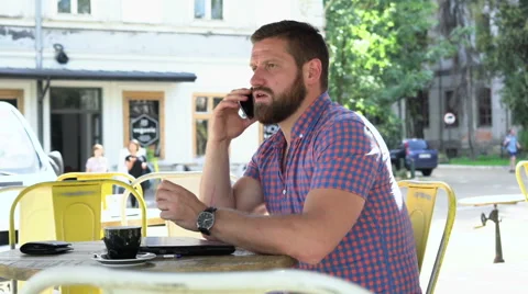 Young man talking by smartphone in cafe, slider shot, left Stock Footage 67632980