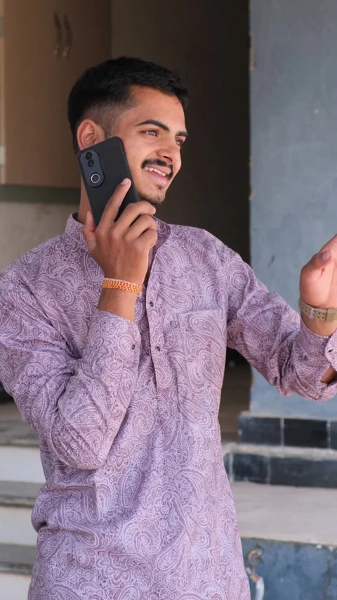 Young Man Talking on Smartphone Outside Home Видео 330738369