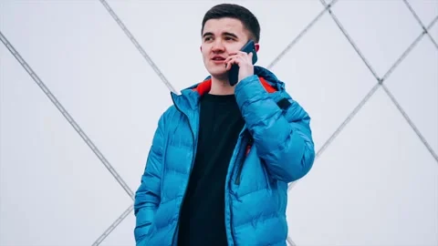 Young man is talking on a smartphone in wintertime Stock Footage 86131942