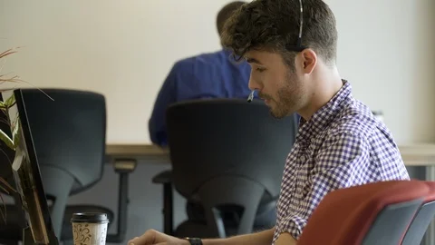 Young man talking through telephone headset in office. Stock-Footage 88025879