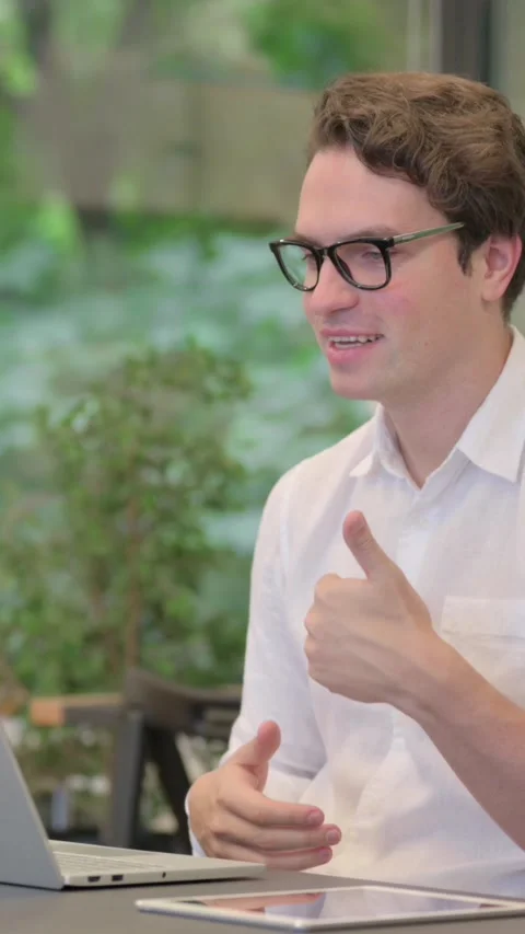 Young Man Talking on Video Call on Laptop in Modern Office, Vertical Video Vídeo Stock 340038633